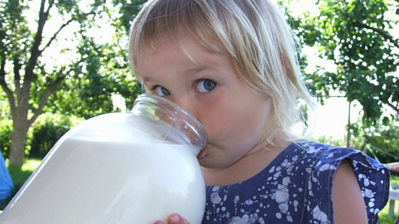 Девочка пьет молоко из банки