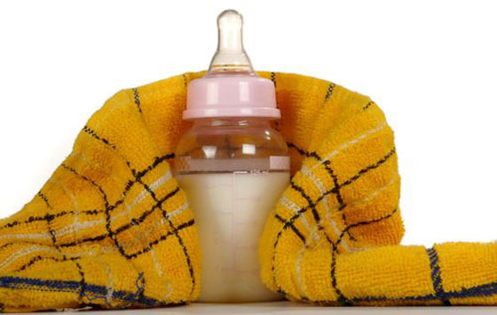 Молоко в бутылочке для ребенка и плед